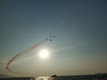 Low angle view of airplane flying over sea against sky