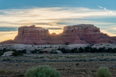 Rock formations on landscape against sky during sunset