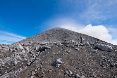 Low angle view of person on rock against sky