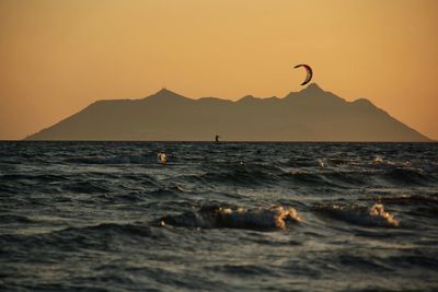 Scenic view of the sea with kite surfer silhouette in the gulf at sunset