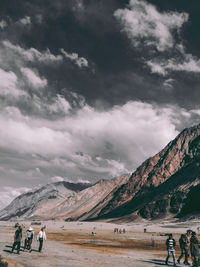 People on mountains against sky