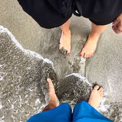 Low section of people standing on beach