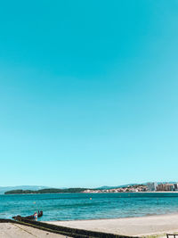 Scenic view of beach against clear blue sky