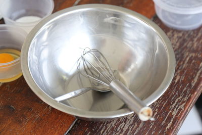 Close-up of wire whisk and spoon on table