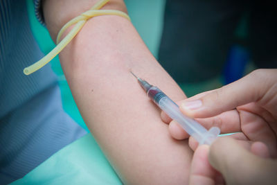 Cropped hand of doctor injecting patient