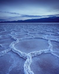 Scenic view of snow covered shore against sky