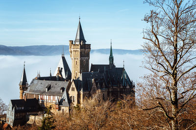 Panoramic view of buildings and trees against sky