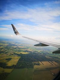 Airplane flying over landscape against sky