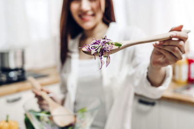 Midsection of woman holding flower on table