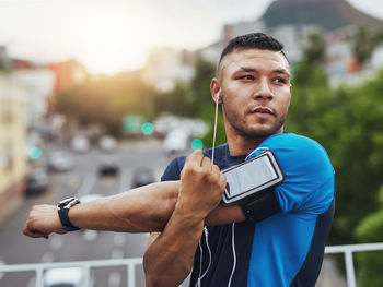 Young man looking away while stretching