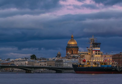 Buildings in city against cloudy sky