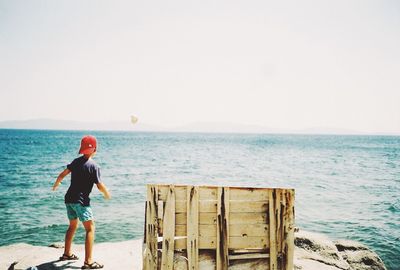 Rear view of man standing on pier