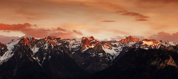 Scenic view of snowcapped mountains against sky during sunset