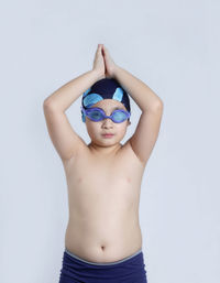 Midsection of shirtless boy against white background