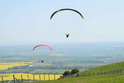 Kite flying over field against sky