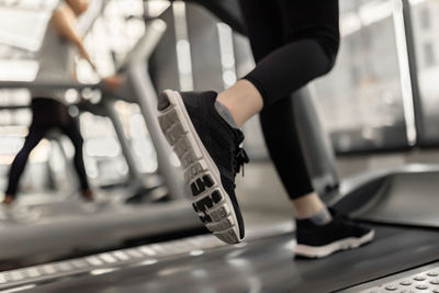 Low section of woman running on treadmill