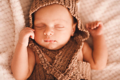 Cute baby boy sleeping on duvet at home