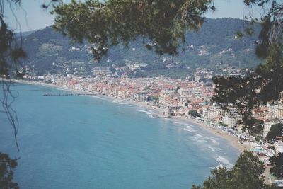 Aerial view of town by sea against sky