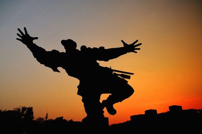 Low angle view of silhouette man against sky during sunset
