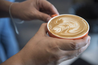 Close-up of hand holding coffee cup