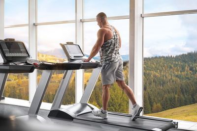 Full length of man exercising on treadmill at gym