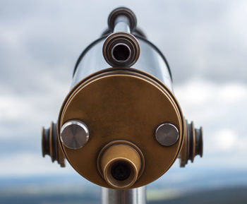 Close-up of coin-operated binoculars against sky