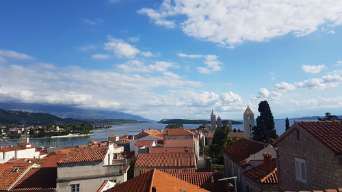 High angle view of townscape by sea against sky