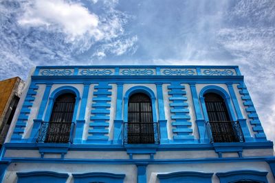 Low angle view of building against cloudy sky