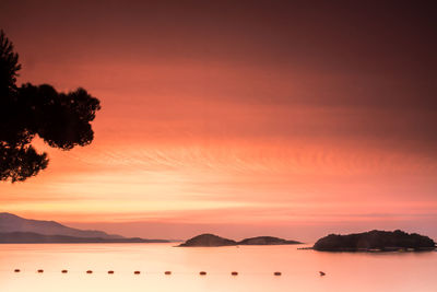 Scenic view of silhouette mountains against orange sky