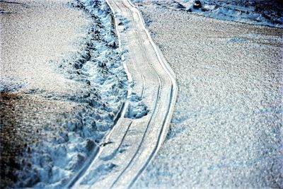 High angle view of footprints on snow covered landscape