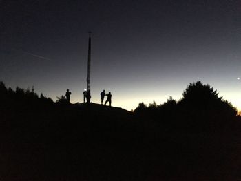 Low angle view of silhouette people on hill against sky