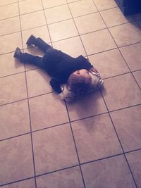 Low section of person sitting on tiled floor
