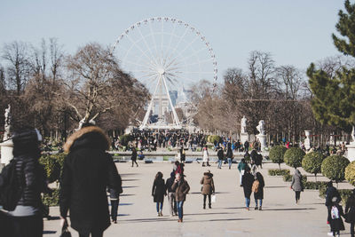 People in amusement park against sky