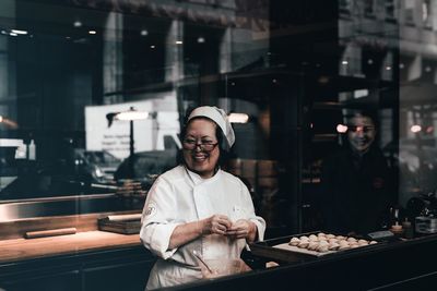 Portrait of smiling man standing at restaurant