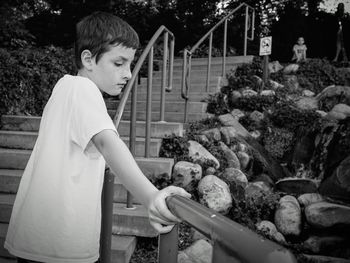 Portrait of boy standing by railing