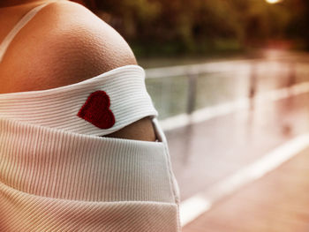 Cropped image of woman wearing off shoulder with red heart shape