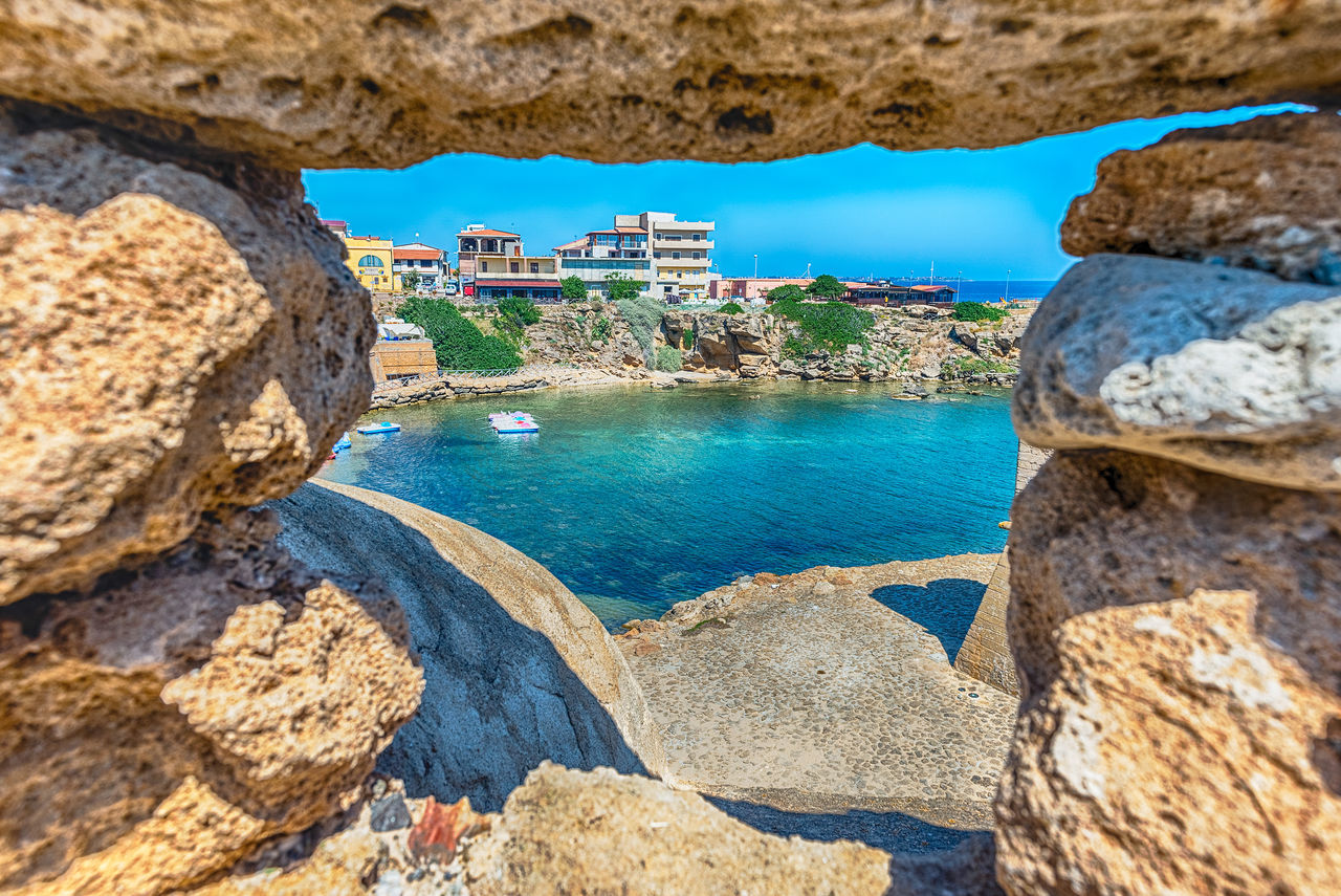 HIGH ANGLE VIEW OF ROCKS BY SEA