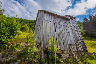 Low angle view of old ruin on field against sky