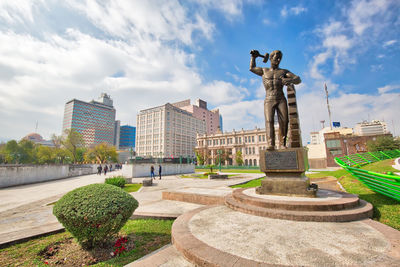 Statue of buildings against cloudy sky