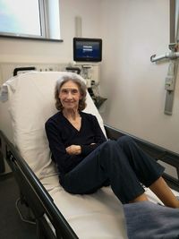 Portrait of senior woman relaxing on bed at hospital