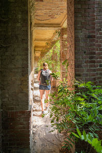 Rear view of woman standing in abandoned building