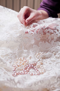 Cropped hands of woman stitching wedding dress