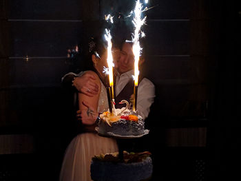 Midsection of woman with candles on birthday cake