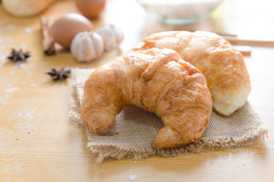 Close-up of croissant and ingredients on table