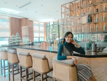 Portrait of young woman sitting at restaurant