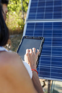 Woman using tablet pc by solar panels