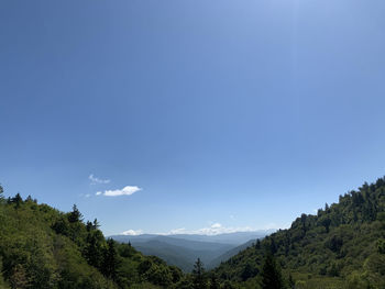 Scenic view of mountains against blue sky