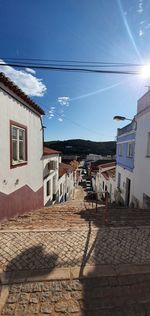 Houses by street in town against sky