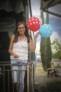 Portrait of girl holding balloons