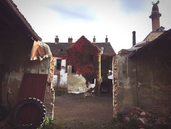 Clothes drying on abandoned house against sky